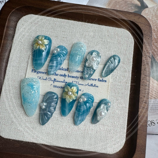 Luxury handmade "Ocean-Breeze" press-on false nails featuring an ocean theme with shell, pearl, and flower petal decorations for an elegant look.