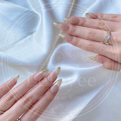 Detailed shot of the thumb nail featuring a bold, wavy gold chrome tip design that blends seamlessly into the natural nail color.