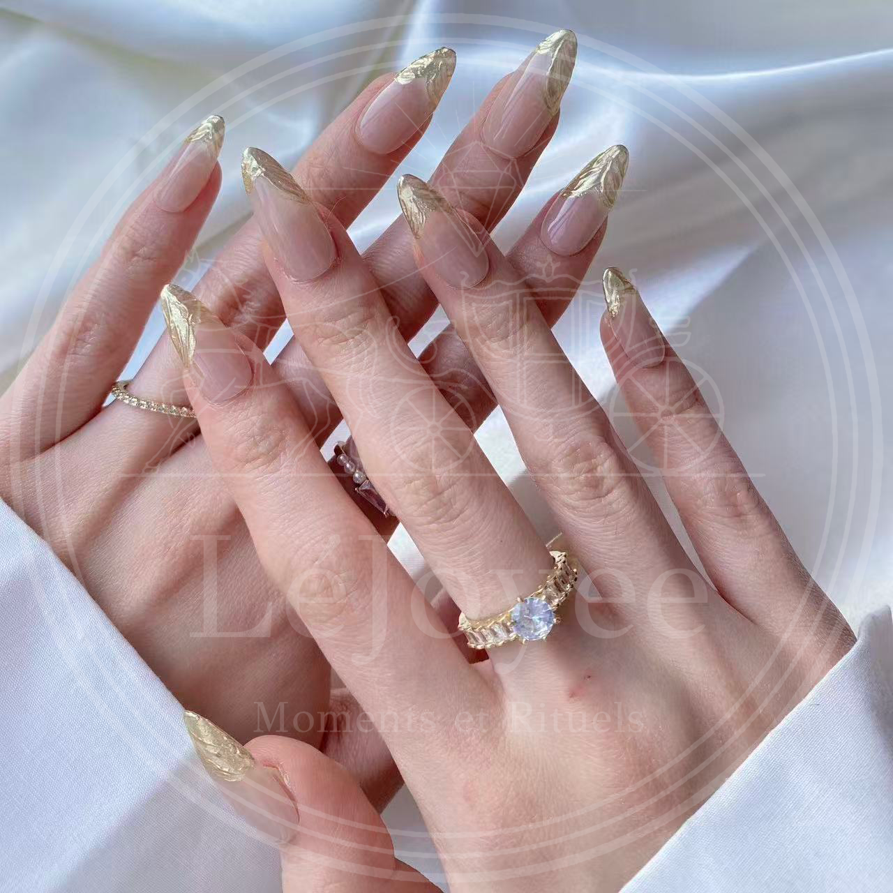 Luxury handmade press-on nails "Gilded Flow" featuring a sheer nude base with textured, molten gold chrome french tips on long almond nails.