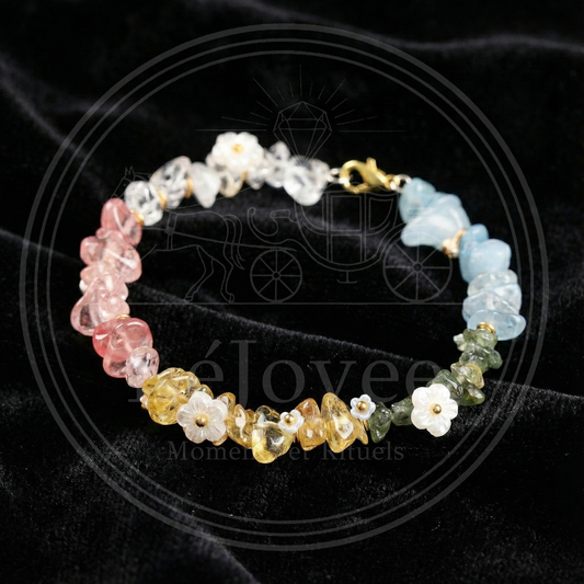 Handmade gemstone bracelet "Luminous Flora" featuring multi-colored natural crystal chips (pink, yellow, green, blue) interspersed with delicate white shell flower charms.