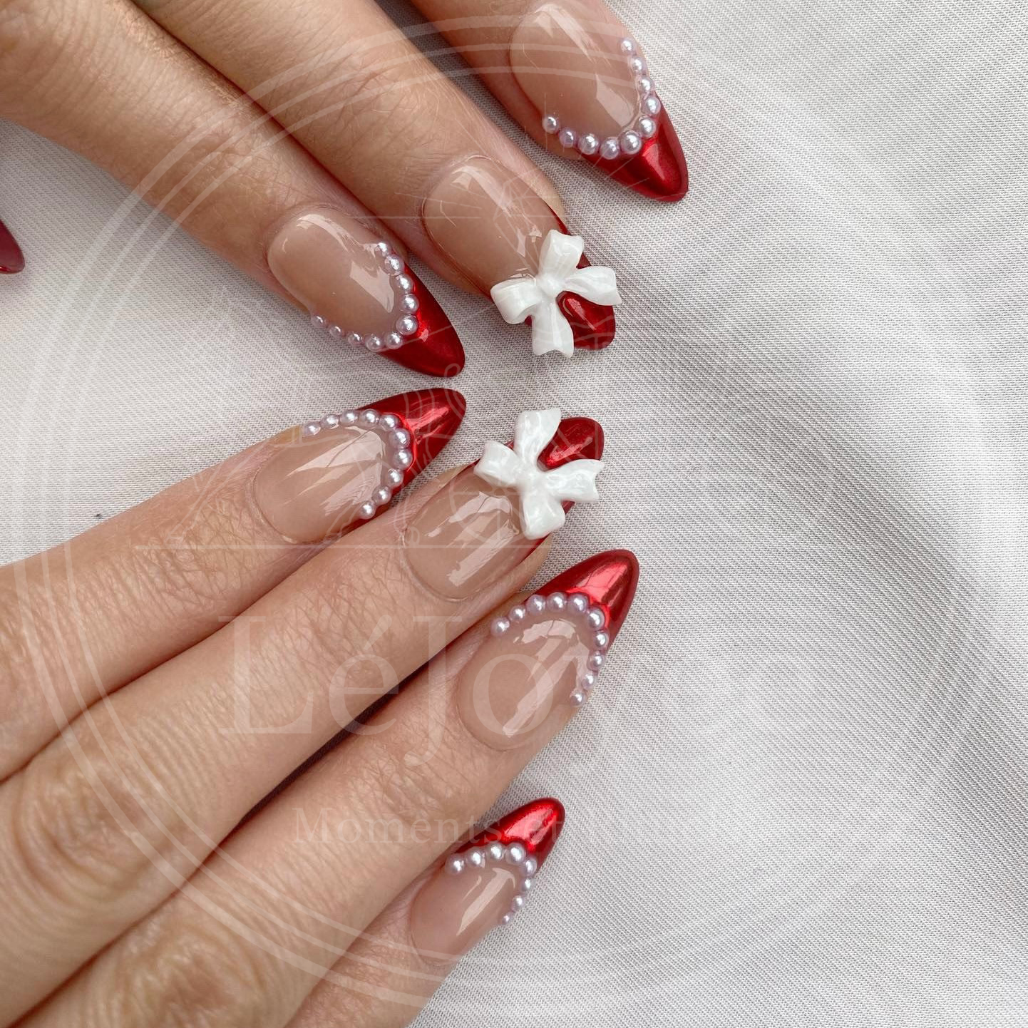 Hand model wearing the "Rouge Coquette" nail set, embodying the trendy coquette aesthetic with a mix of bold red and sweet feminine details.