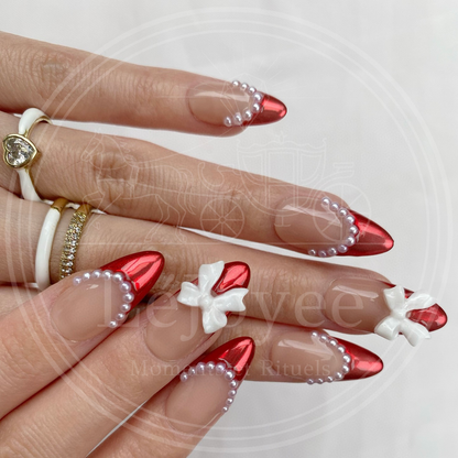 Side profile shot of the almond nails showing the raised height of the 3D bow and the smooth curve of the pearl embellishments.
