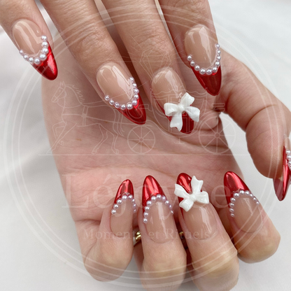 Elegant red and white festive press-on nails perfect for Christmas or Valentine's Day, featuring gift-wrap style ribbon art.