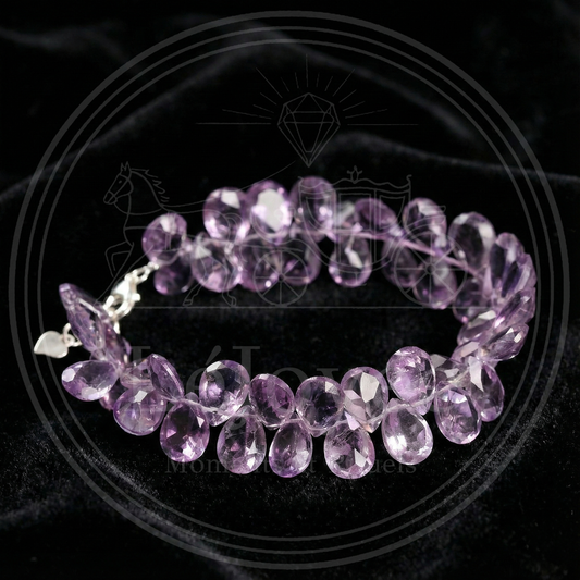 Close-up showing the exquisite waterdrop-shaped briolette cut of the natural amethyst crystals, highlighting their clarity and the silver clasp detail. 