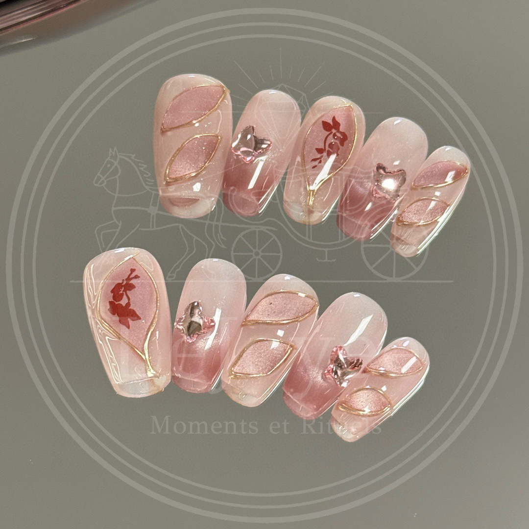 Close-up of a vintage red rose silhouette encased in a gold wire frame on a mauve ombre nail.