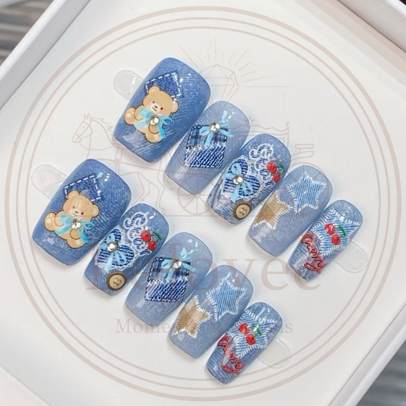 Wrap your fingertips in timeless retro denim.
This designed press on nails features a beautifully realistic washed-denim texture as the backdrop, paired with teddy bears and cherry motifs for a touch of youthful whimsy.

Every detail hits the mark: delicate “contrast stitching,” vintage distressed plaid patches, and sparkling rhinestones recreate the sweet-and-cool Y2K aesthetic. It blends the effortless spirit of American street style with a playful, girlish charm.