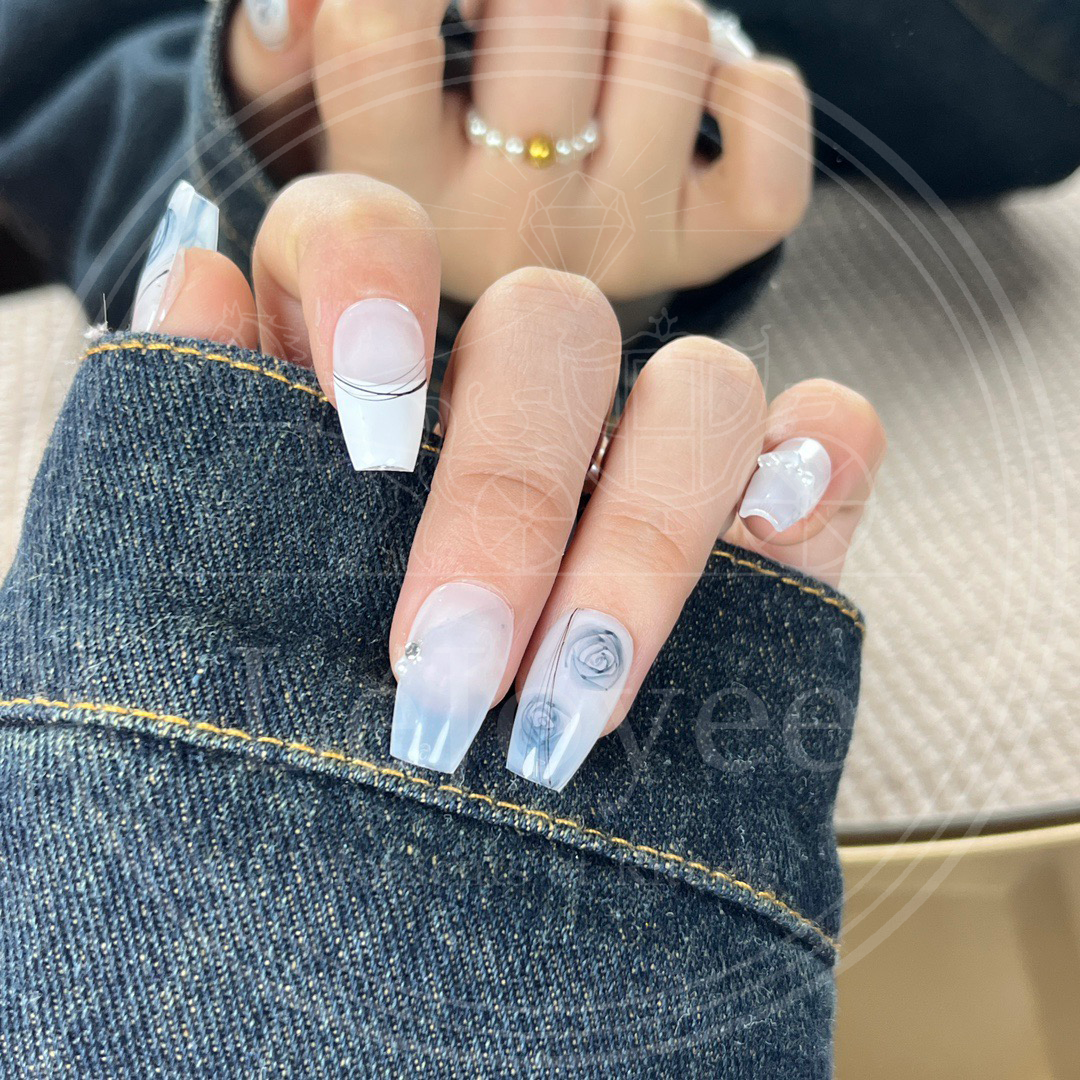 Close-up of the watercolor-style blue rose design on a semi-sheer white nail, resembling traditional blue and white porcelain art.