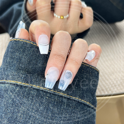Close-up of the watercolor-style blue rose design on a semi-sheer white nail, resembling traditional blue and white porcelain art.