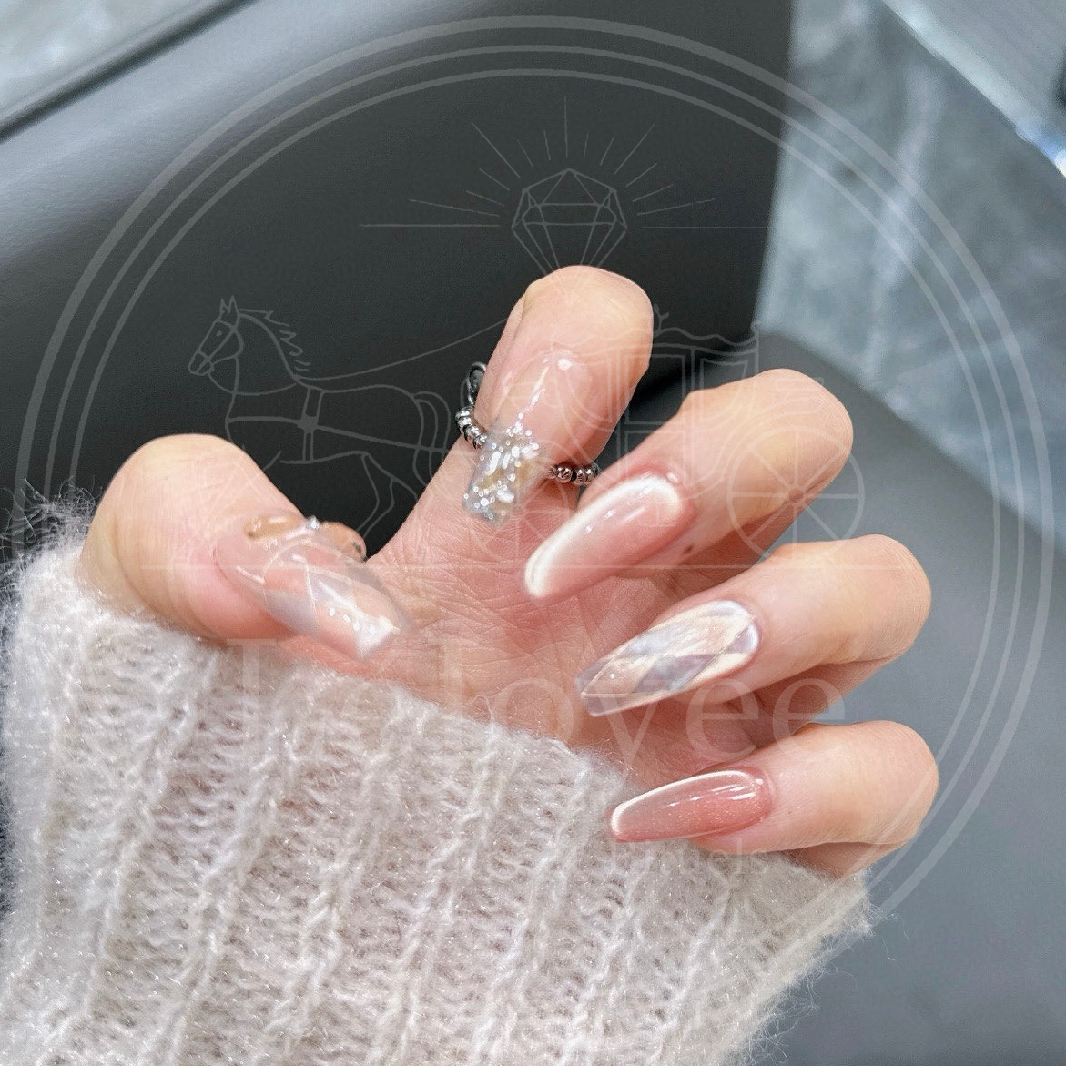 Angled close-up of the long coffin nails, highlighting the reflective glowing cat-eye effect on the peach nails and the sparkle of the glitter gradient nail.