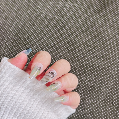 Two variations of the "Celestial Odyssey" nail set: one in sunset purple-pink hues and another in misty mountain green-yellow tones, both featuring mythical eastern art.