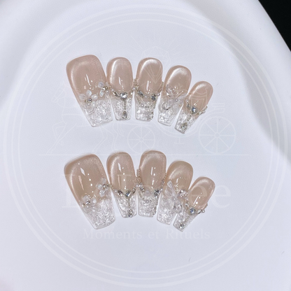 High-angle shot showing the contrast between the shimmering nude magnetic base and the transparent, ice-like textured tips of the Glass Serenade nail set.