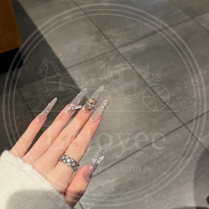 Luxury bridal-inspired press-on nails with embellishments and translucent nude finish, perfect for weddings or events.