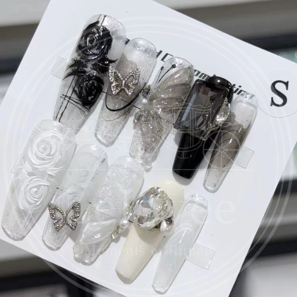 Luxury handmade "Prismatic Butterfly" press-on nails, featuring a gemstone-shape design with dramatic black-and-white roses, rhinestone butterfly charms, and sparkling glitter accents.