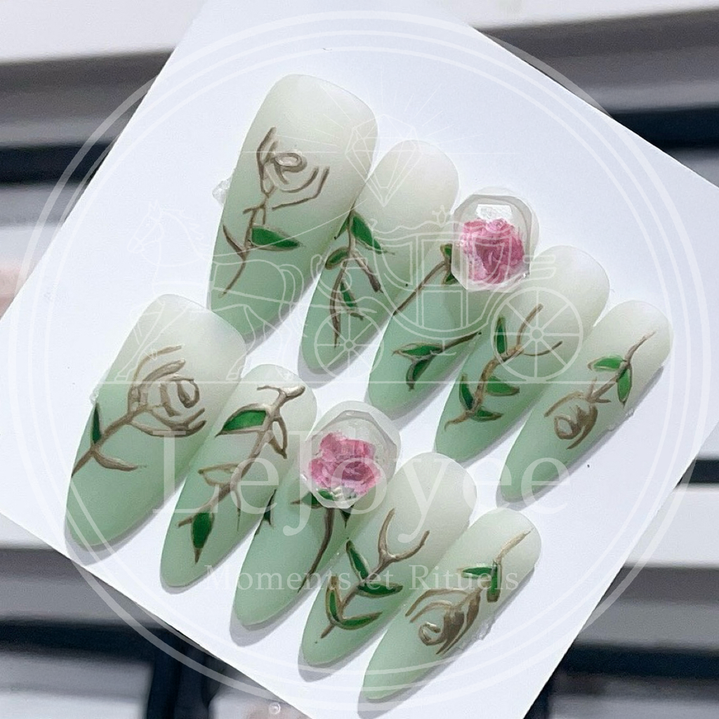 Luxury handmade "Rose-Ivy" press-on nails, featuring a fresh green gradient background, pink roses encased in a gem-shape design, and elegant, carved green leaf accents.