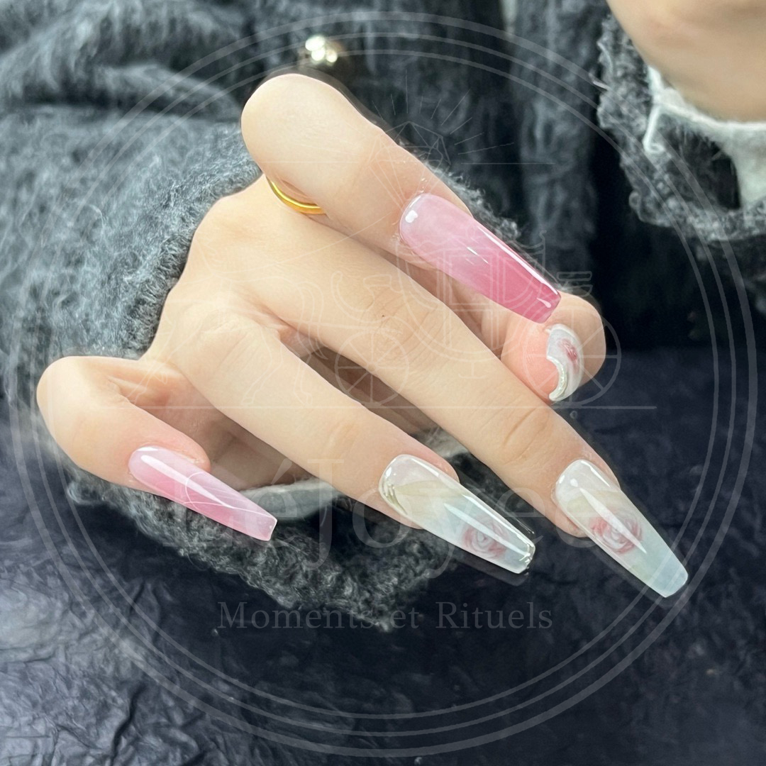Macro view capturing the glossy, porcelain-like finish of the nails and the delicate, watercolor-like transparency of the floral petals.