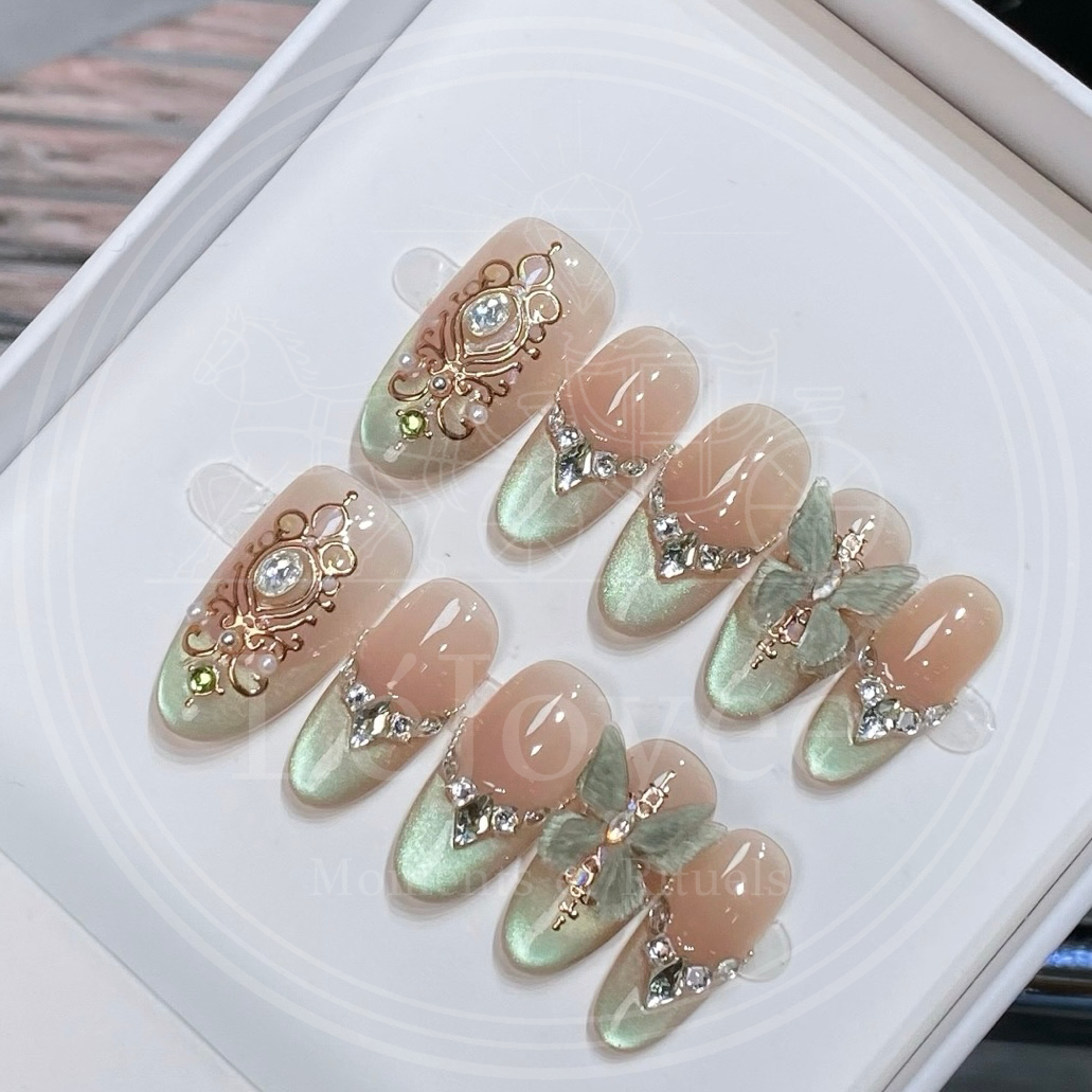 Luxury handmade press-on nails "Sage Baroque" featuring soft sage green magnetic cat-eye tips, intricate gold-coloured baroque relief art, and 3D butterfly charms