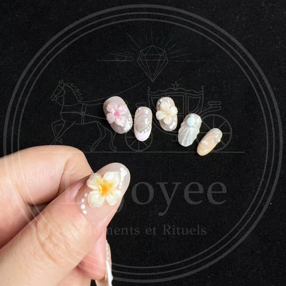 Macro shot highlighting the pearlescent ridged seashell texture, tiny pearl accents, and miniature starfish gems on the beach-themed accent nails.