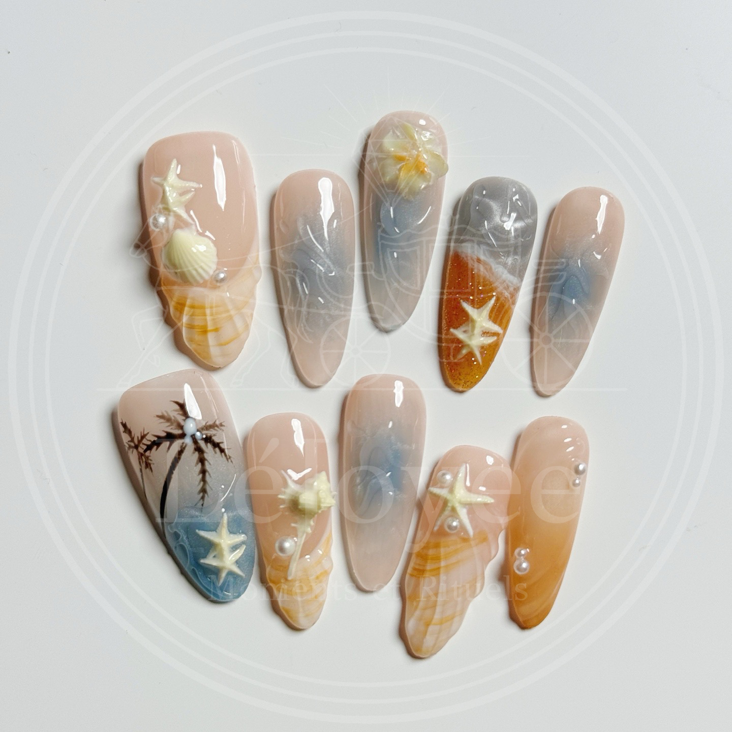 A tropical vacation-ready nail set displayed on a white background, showcasing the contrast between warm sunset oranges and cool ocean blues.