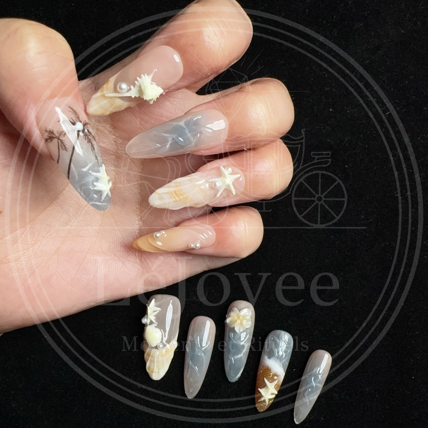 Macro shot showing the textured, ridged surface of a 3D shell nail in a warm amber and nude gradient, accented with pearls.