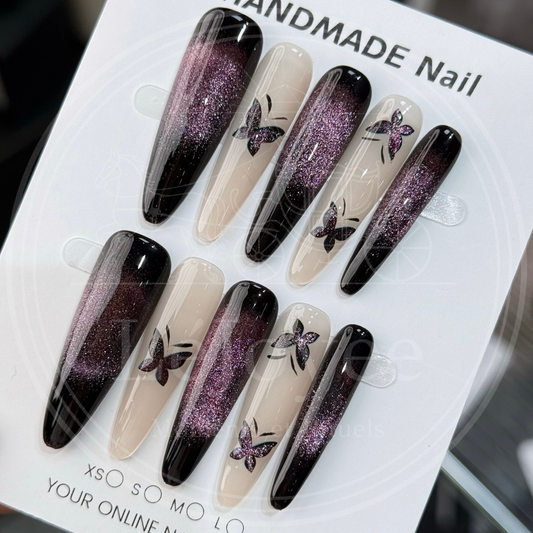 Luxury handmade press-on nails "Violet Nocturne" featuring a deep purple magnetic cat-eye gradient and delicate black butterfly nail art on a long shape.