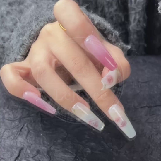 Video capturing the way the glossy top coat reflects light, enhancing the depth of the pink gradient and the vibrancy of the floral design.