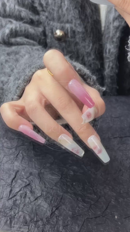 Video capturing the way the glossy top coat reflects light, enhancing the depth of the pink gradient and the vibrancy of the floral design.