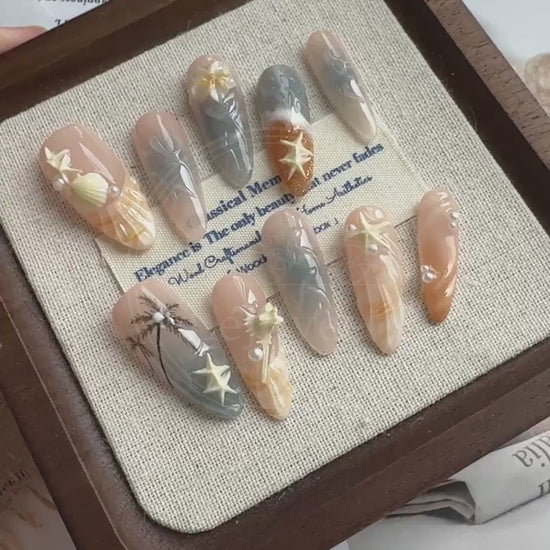 Video demonstrating the raised ridges of the 3D shell design and the glossy, wet-look finish of the water marble art on the Sunset Cove nails.