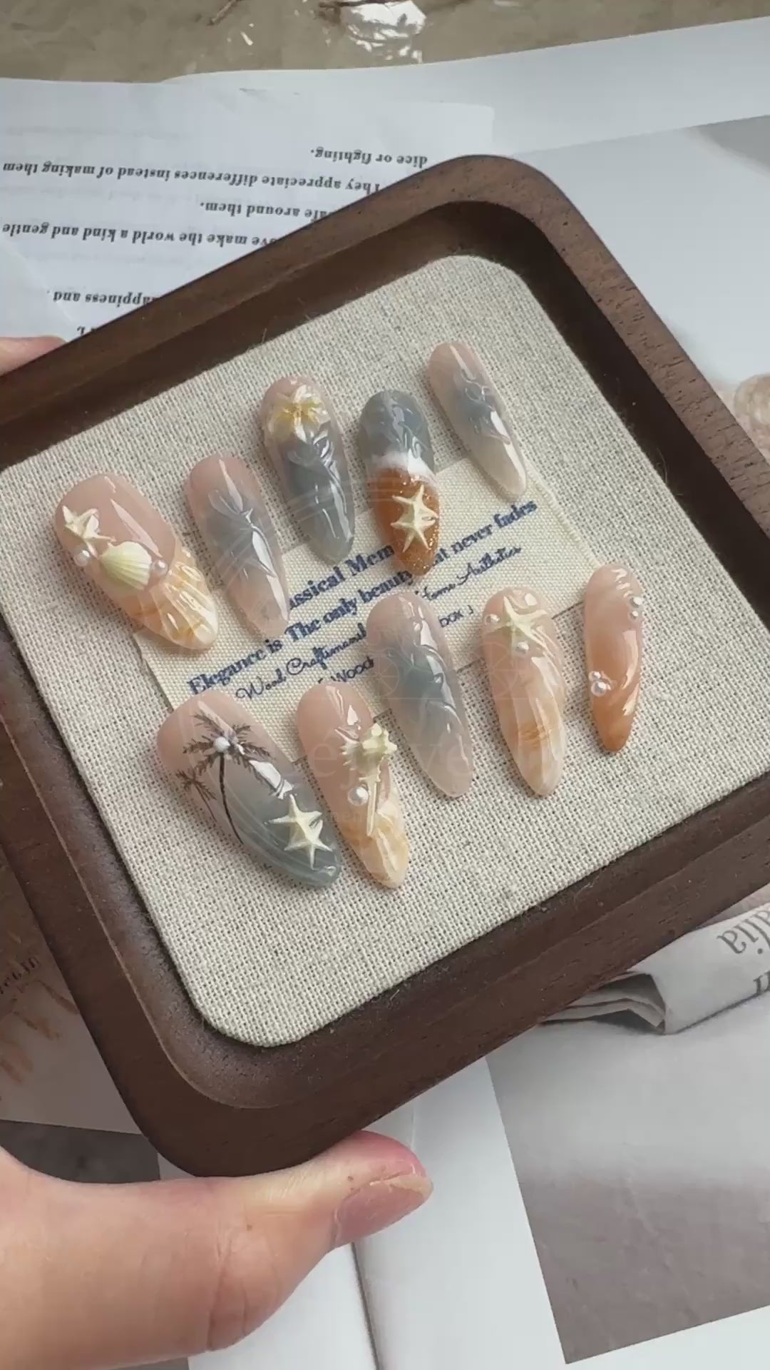 Video demonstrating the raised ridges of the 3D shell design and the glossy, wet-look finish of the water marble art on the Sunset Cove nails.