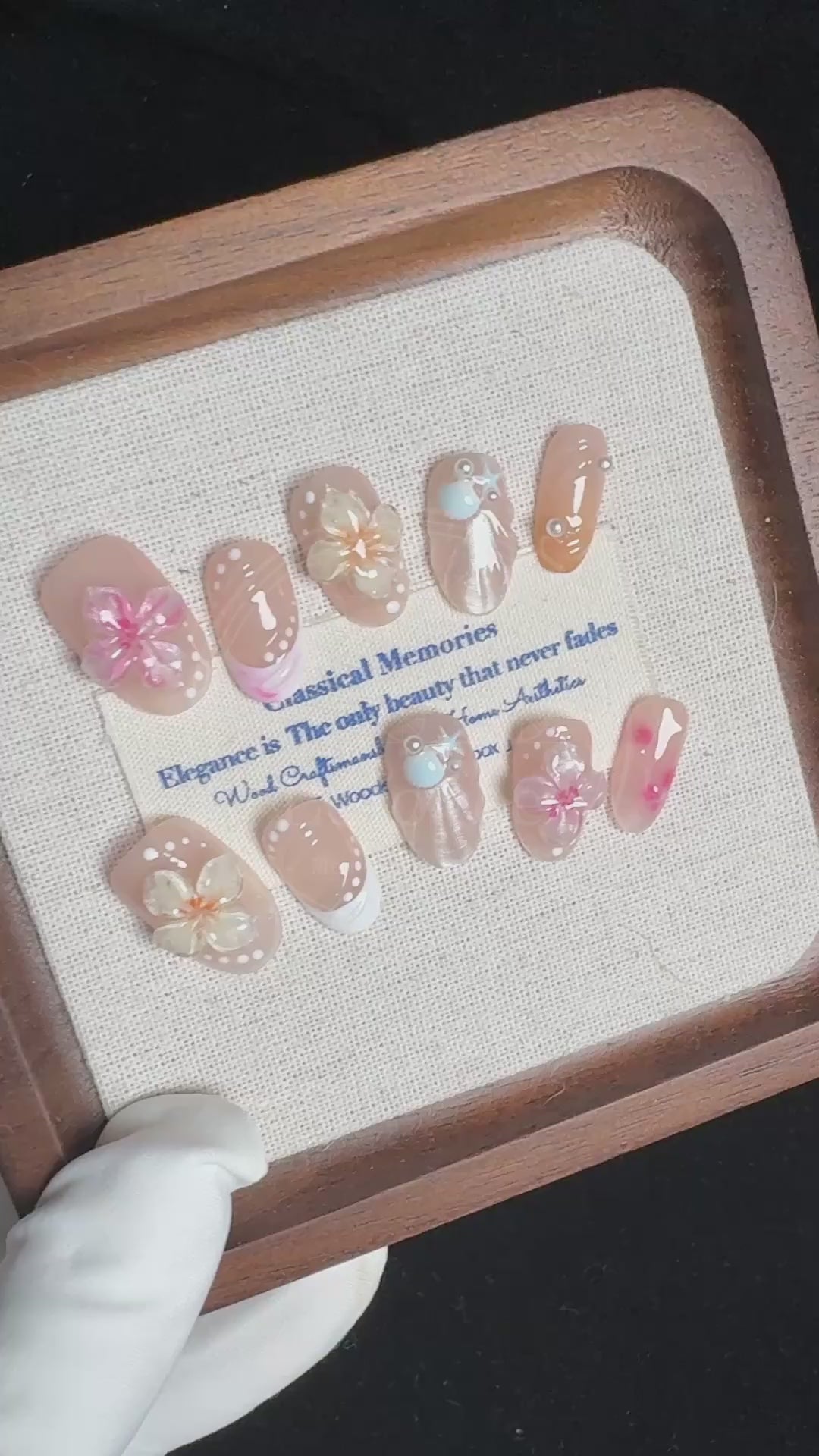 Video demonstrating the glossy finish and the raised, dimensional texture of the jelly sakura flowers and shimmering seashells on the Sakura Shores nails.