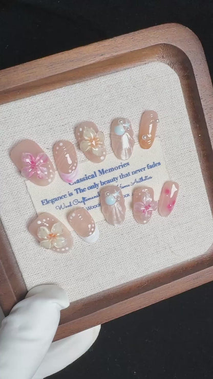 Video demonstrating the glossy finish and the raised, dimensional texture of the jelly sakura flowers and shimmering seashells on the Sakura Shores nails.