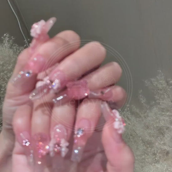 A luxurious pink floral handmade press-on nail set with sparkling rhinestones and accents, reflecting feminine elegance and soft beauty.