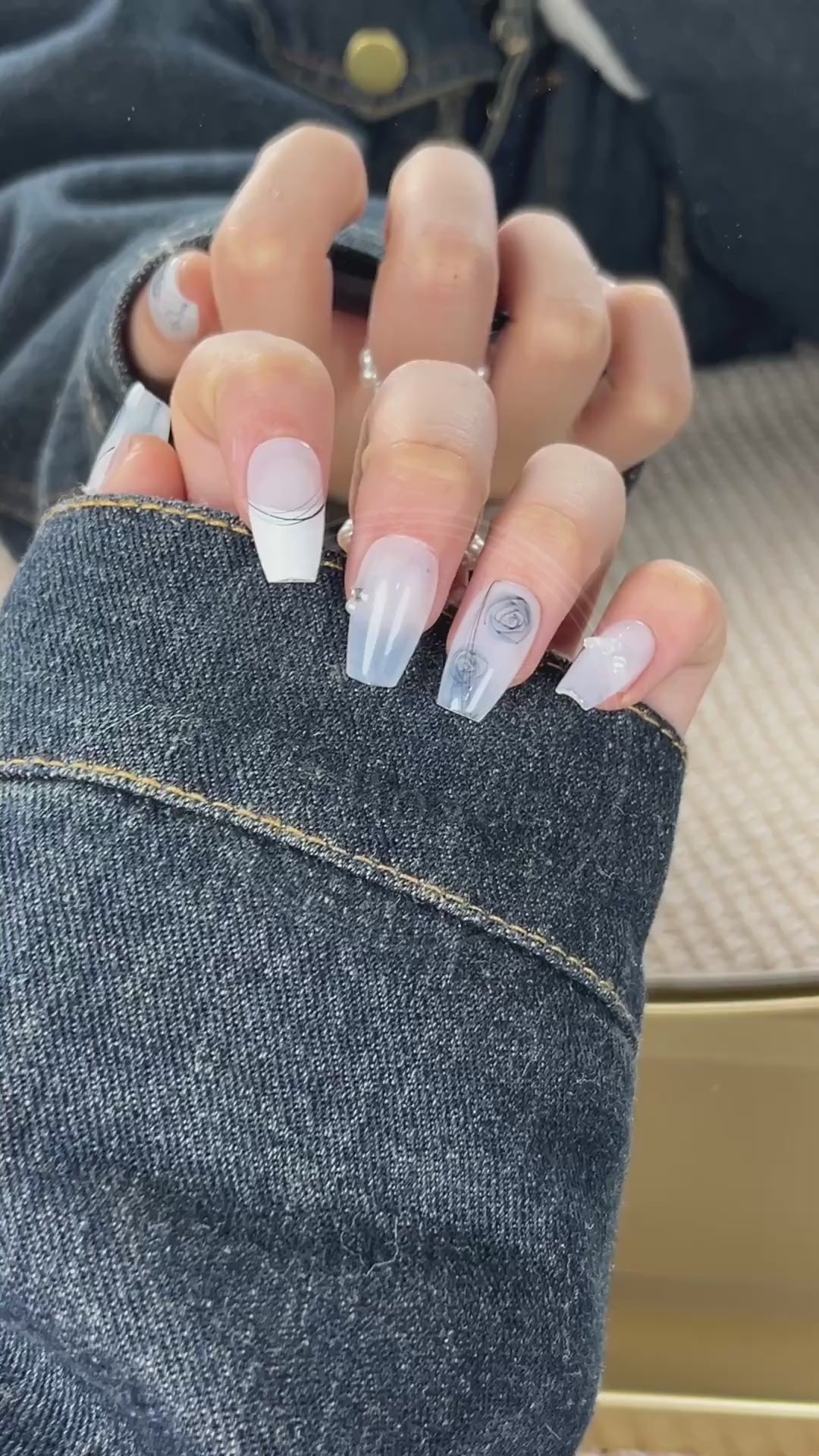 Video showcasing the smooth, porcelain-like finish of the white base and the delicate details of the hand-drawn blue roses on the Azure Sketch nails.