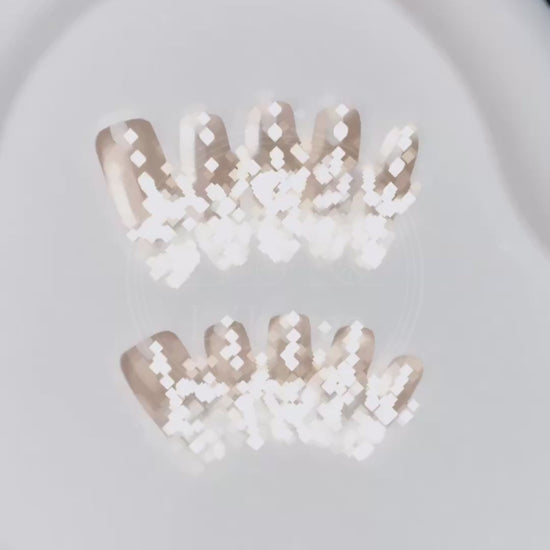Video showcasing the light passing through the clear "crushed ice" french tips and the shimmer of the pearl details on the Glass Serenade press-ons.